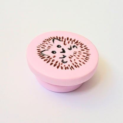 Light pink needle minder with brown and black hedgehog imprinted design.