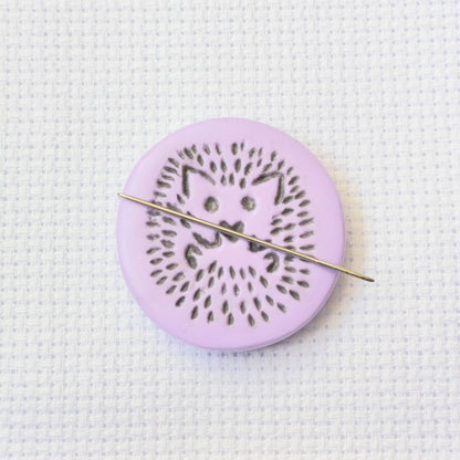 Purple needle minder with grey hedgehog imprinted design.