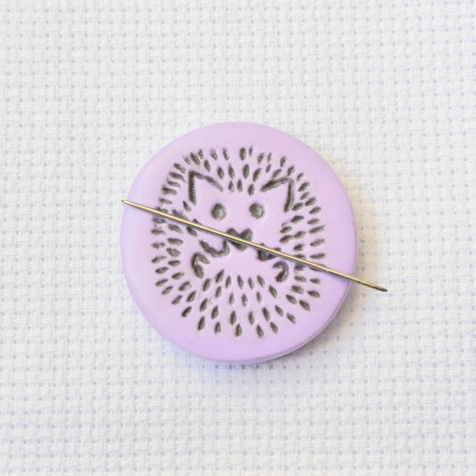 Purple needle minder with grey hedgehog imprinted design.