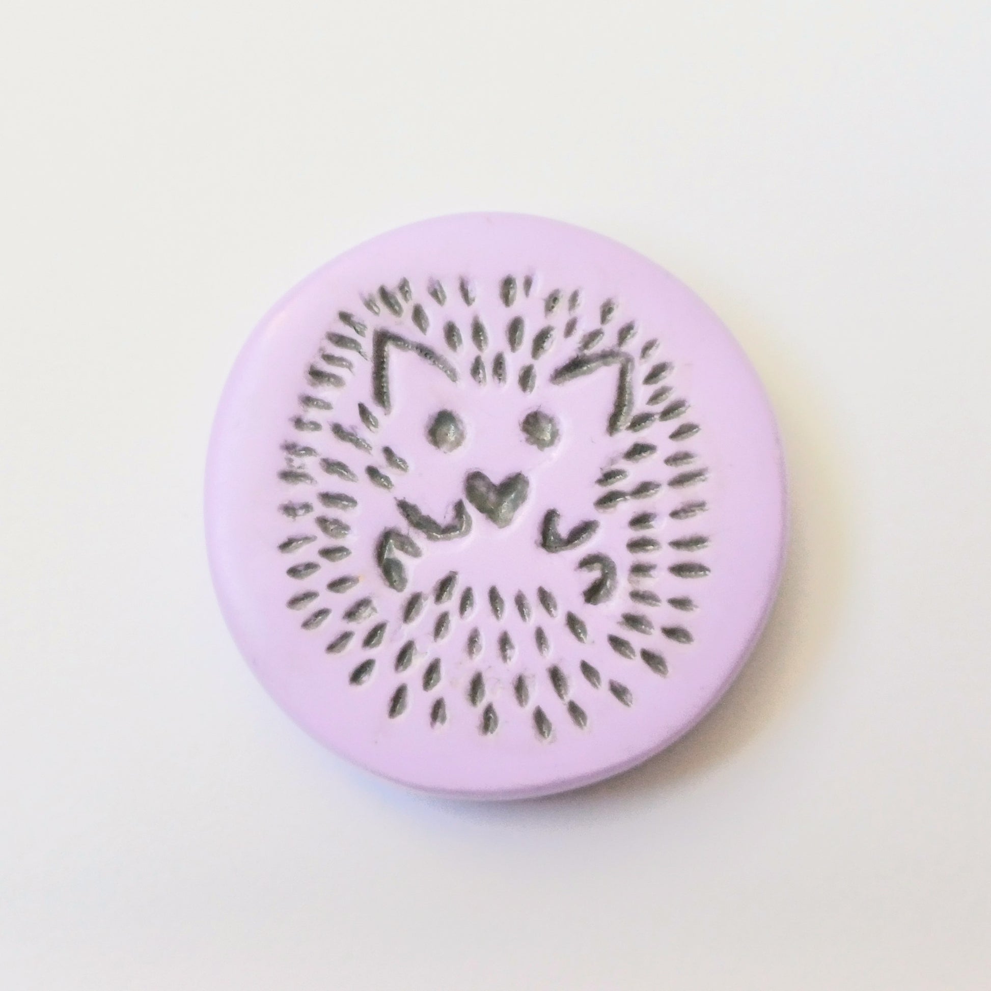 Purple needle minder with grey hedgehog imprinted design.