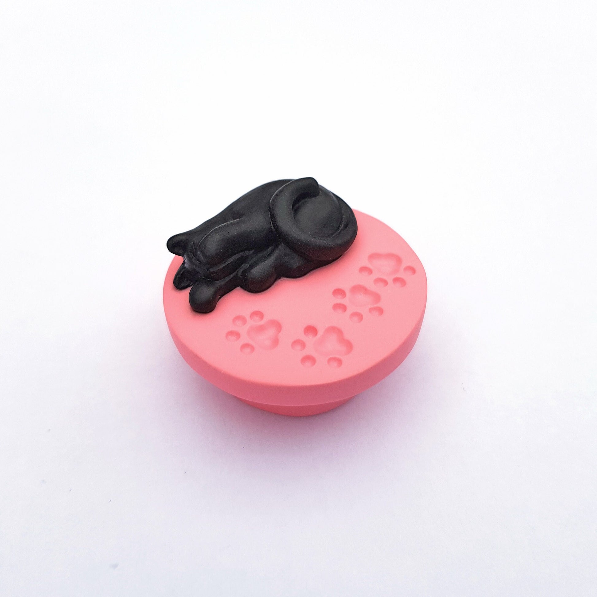 Black cat on pink paw print base needle minder for cross stitching.