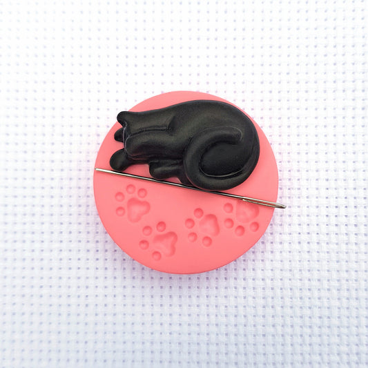 Black cat on pink paw print base needle minder for cross stitching.