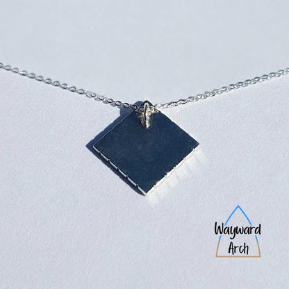 Back view of square sterling silver pendant with smooth polished finish showing the hidden jump ring fitting in one corner that the chain runs through.